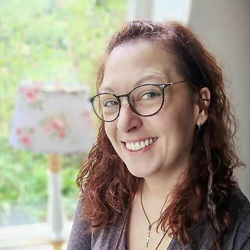 Sylvia Johanson steht lächelnd im Vordergrund und strahlt Wärme aus, was ideal für die Betreuung von Demenzkranken ist.